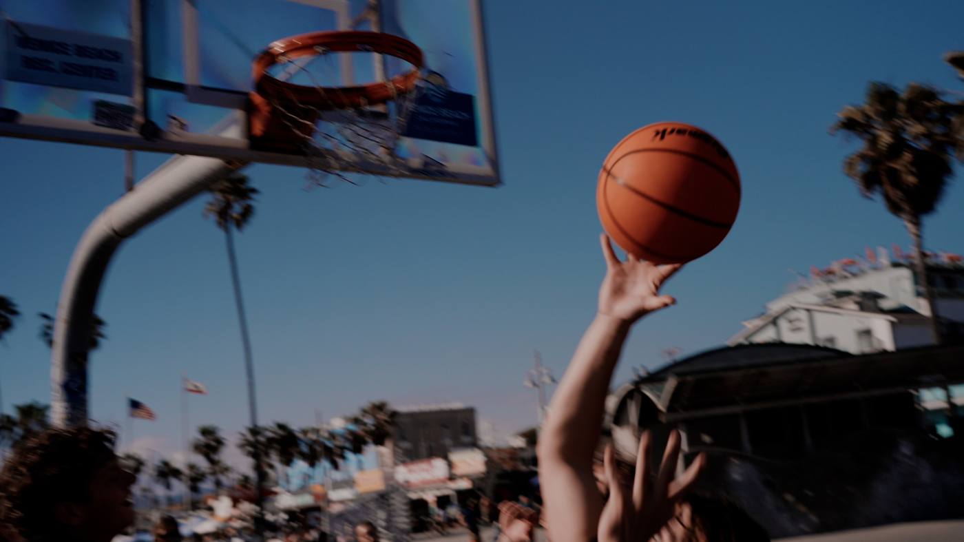Player reaching for a shot against palm tree skyline at Venice Beach