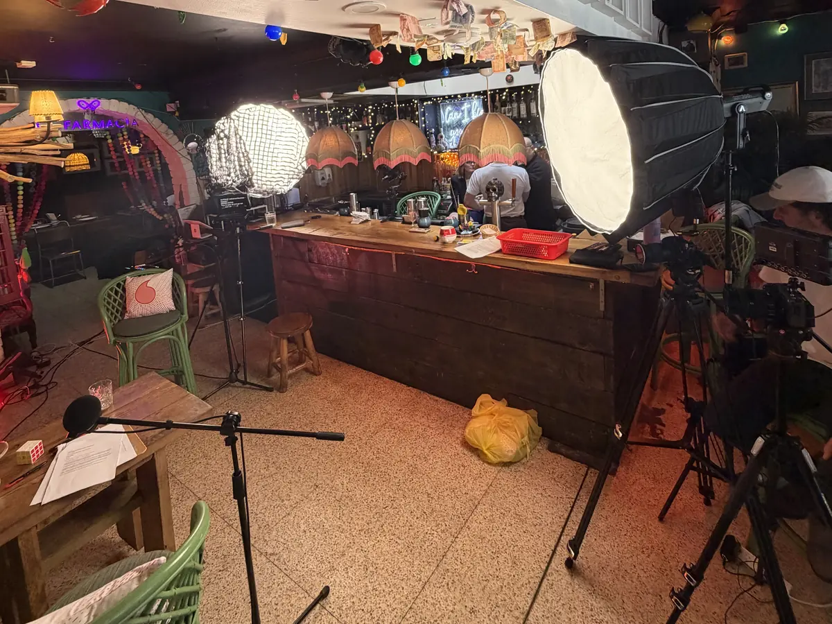 Lit interview setup with softboxes and cinema cameras behind the bar of a small venue, ready for an on-location testimonial shoot