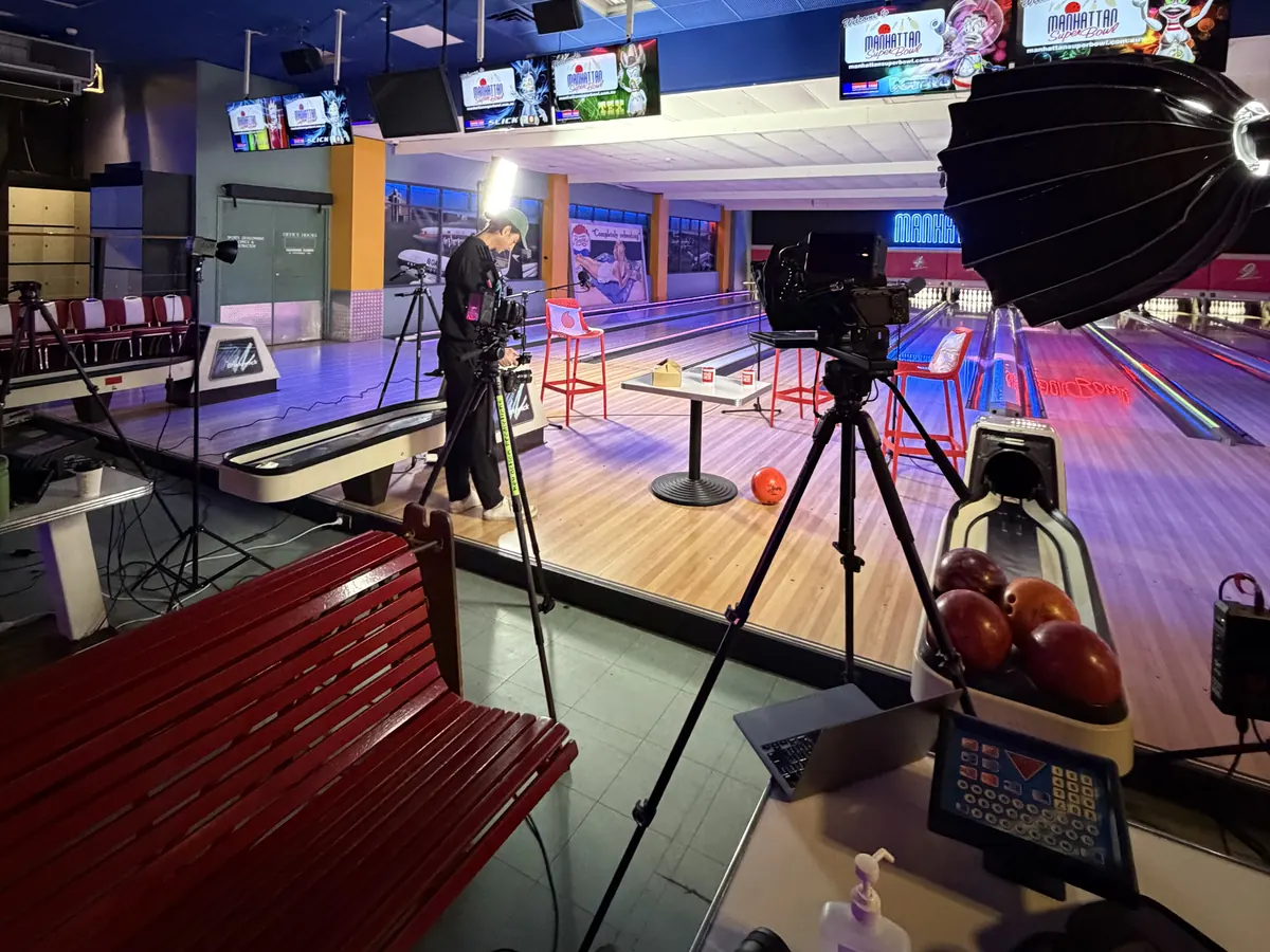 Lit interview setup with softbox and cinema camera inside a bowling alley for an on-location testimonial shoot